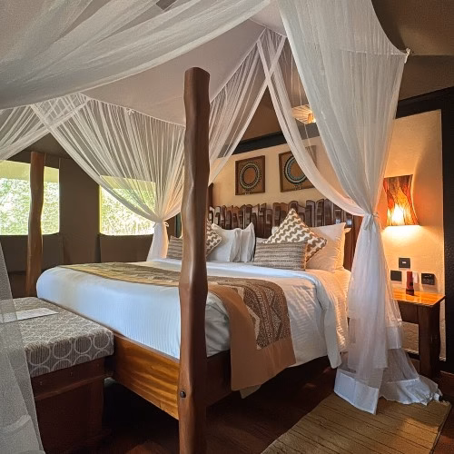 Bed with mosquito net at Sarova Mara